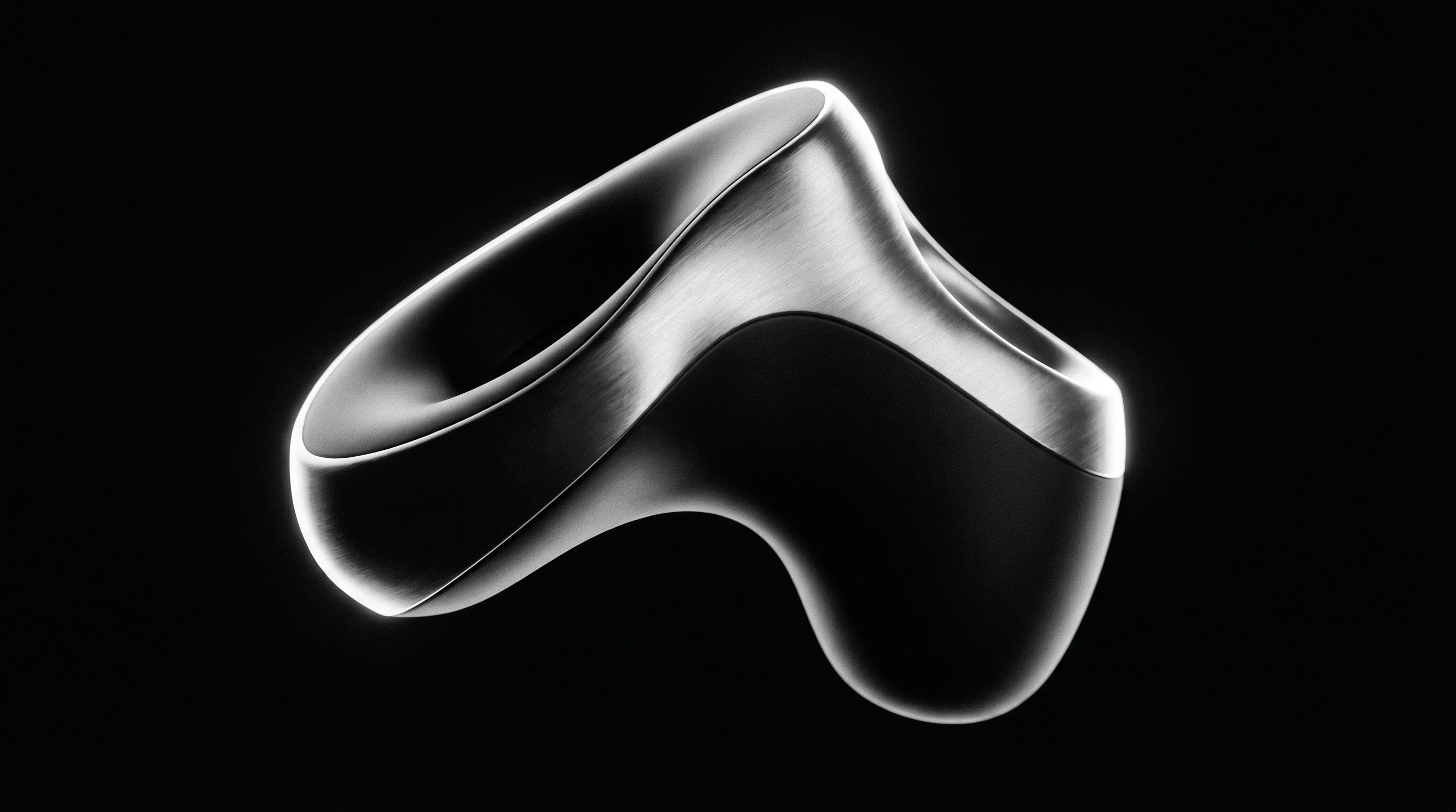 Macro still of a sculptural brushed-aluminium wearable form floating on black, lit by a single rim light.